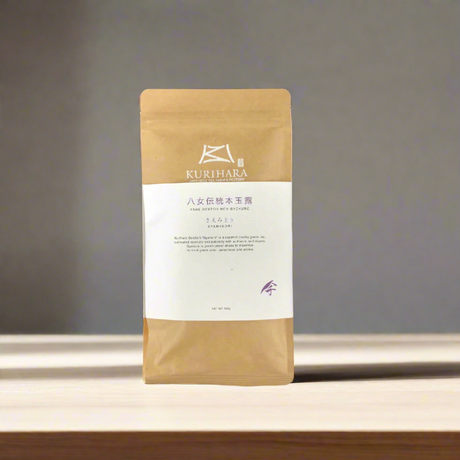 Kurihara coffee package on a wooden surface with a gray background